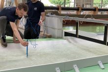 Wissenschaftlicher Mitarbeiter misst mit einem Messgegerät die Kraft des durchströmenden Wassers.