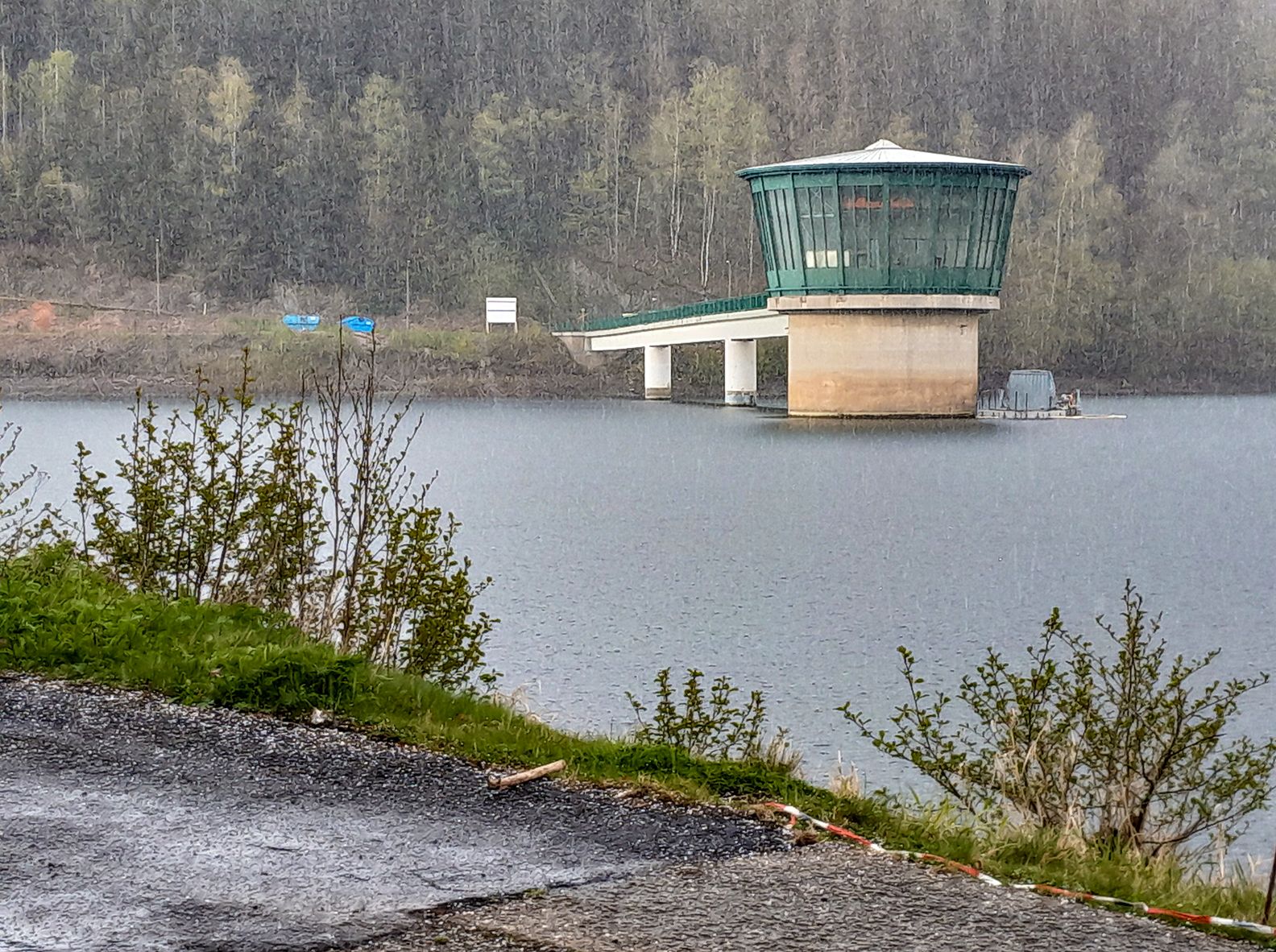 Halbtotale des Entnahmeturms der Talsperre Schönbrunn in einem leichten Schneeschauer