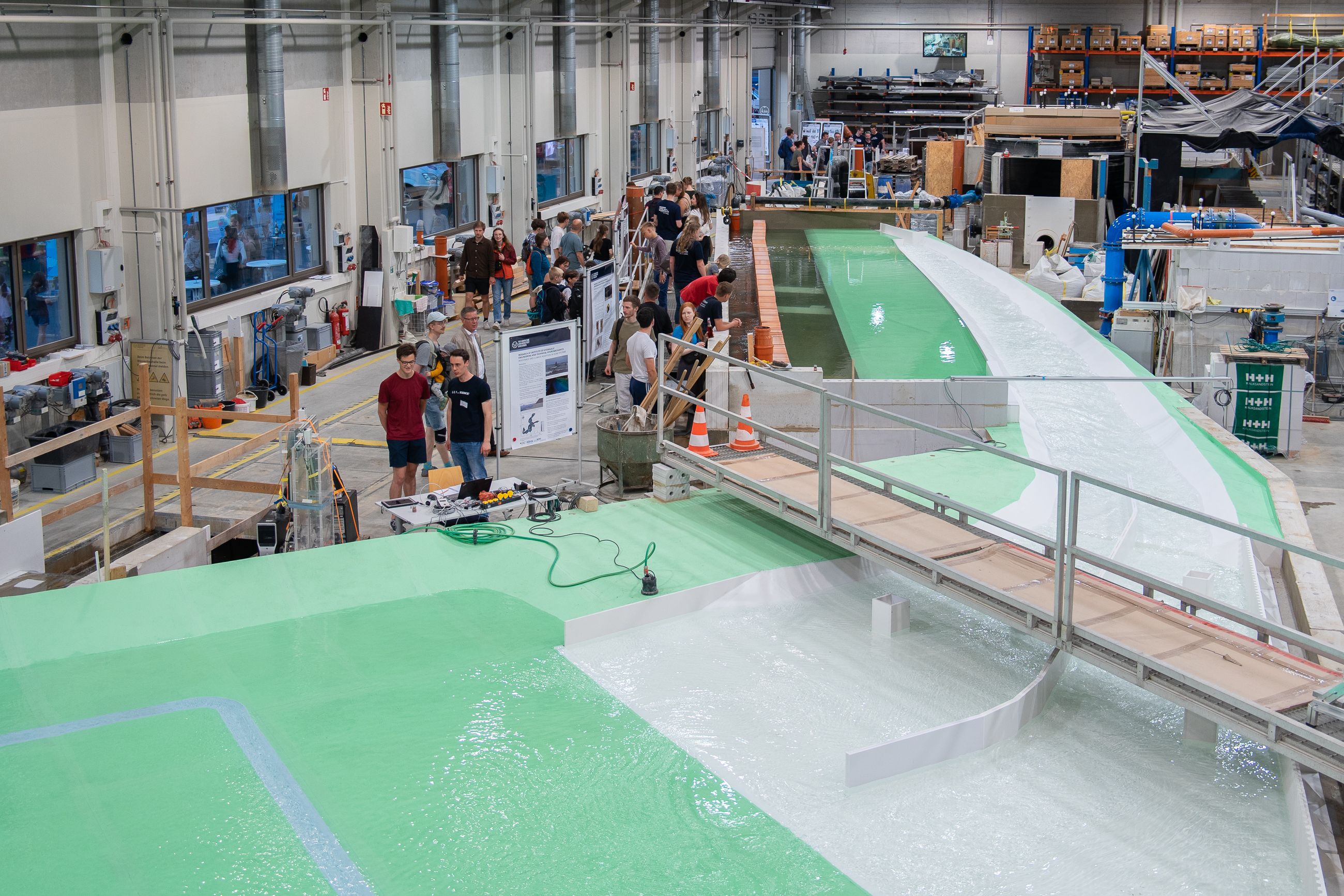Vogelperspektive auf das Miniaturmodell und auf Besuchende der Langen Nacht der Wissenschaften im Wasserbaulabor an der TU Dresden.