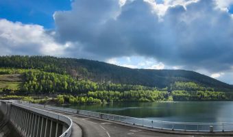 Blick auf den Stausee der Talsperre Leibis Lichte an einem bewölten Frühlingstag, im Hintergrund ein bewaldeter Berghang