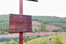 Schild zur Ausweisung des Wasserschutzwaldes und im Hintergrund der Steilhang sowie die Talsperre Ohra