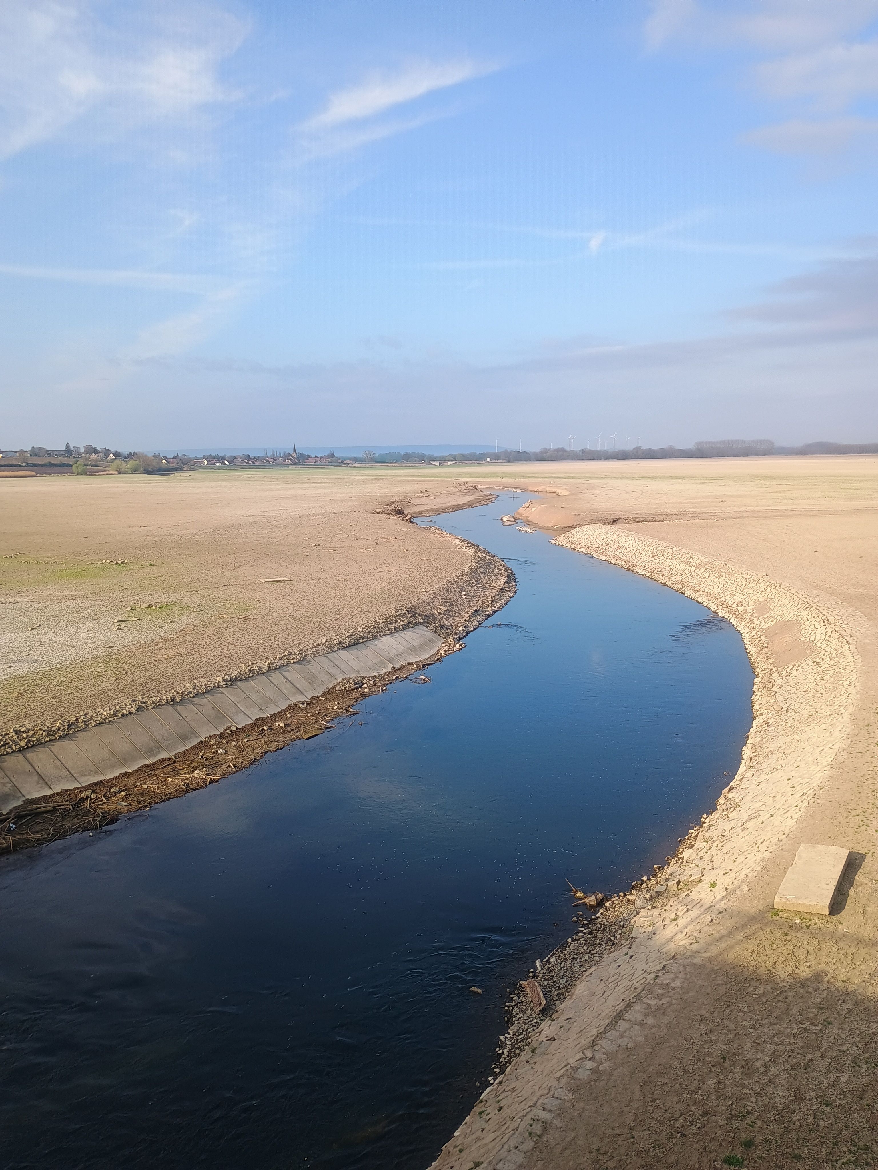 Leerer Stauraum und in der Mitte schlängelt sich die Unstrut mit ihrem blauen Wasser durch das Staubecken.