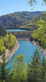 Aufnahme bei Sonnenschein. Im Vordergrund sind Baumspitzen des Waldes zu sehen, dahinter ist der Ausläufer der Talsperre Leibis Lichte und das obere Becken der Vorsperre Deesbach zu sehen. beide Becken sind mit blauem Wasser gefüllt.