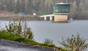 Halbtotale des Entnahmeturms der Talsperre Schönbrunn in einem leichten Schneeschauer