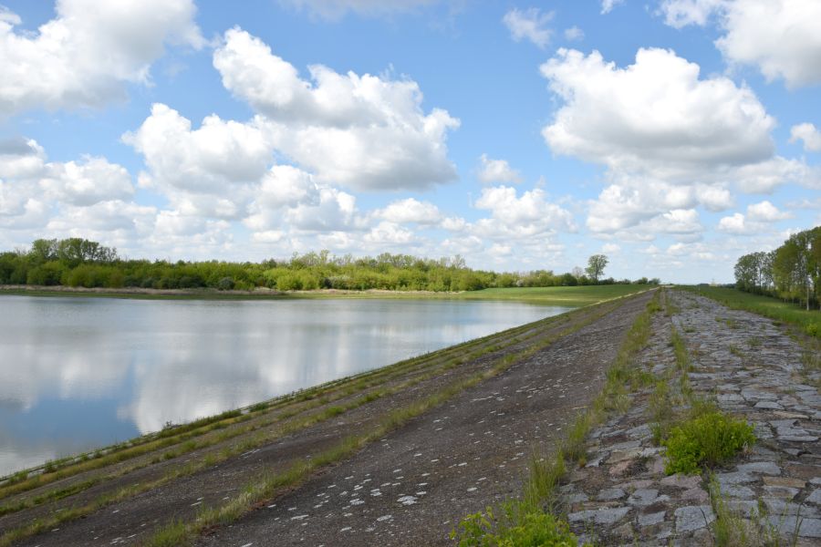 Sonne blitzt durch die Wolken hervor auf die Talsperre Vippachedelhausen