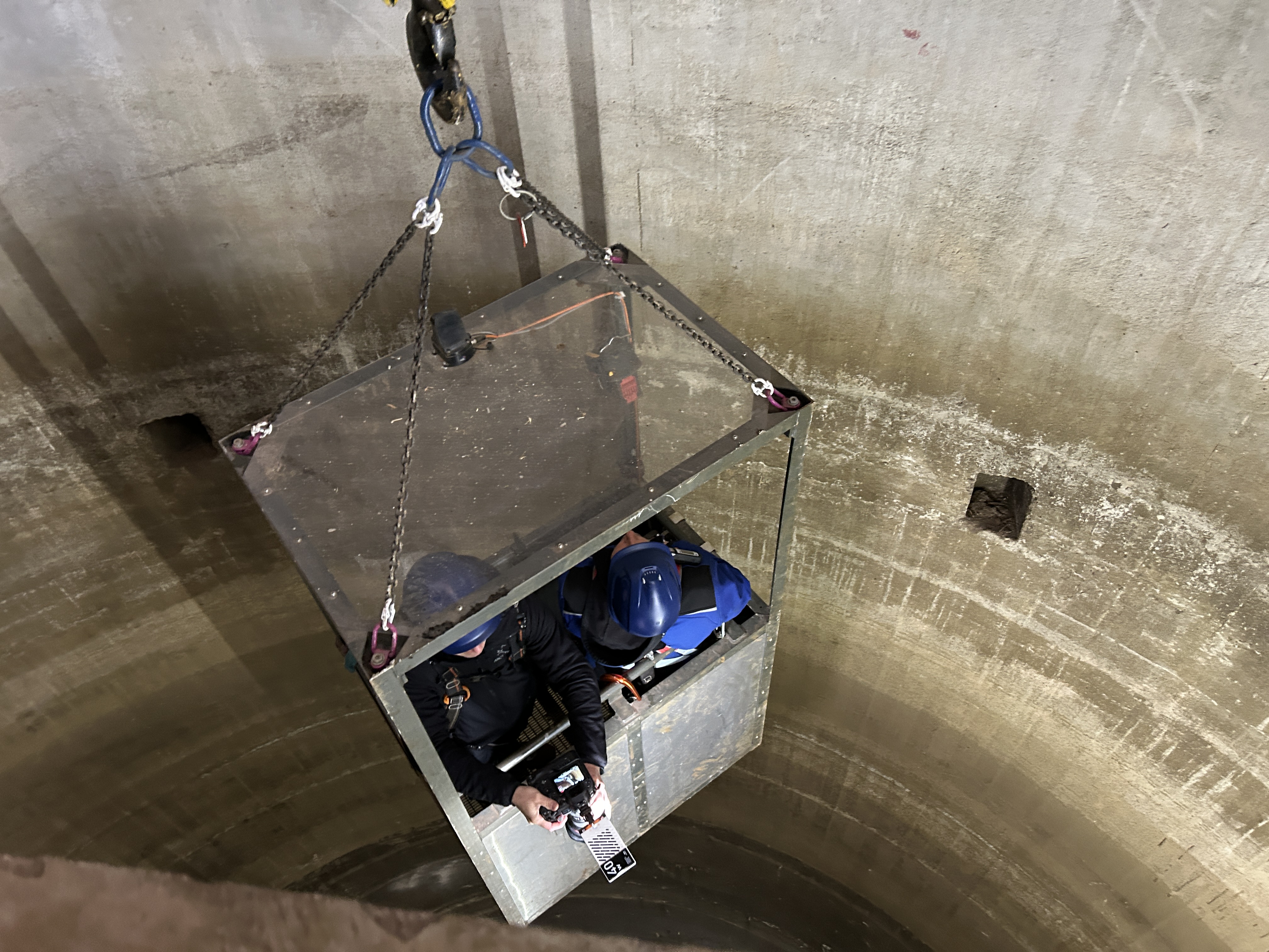 Zwei Personen fahren mit dem Personenkorb am Seilzug hinab in den 60 Meter hohen Turm