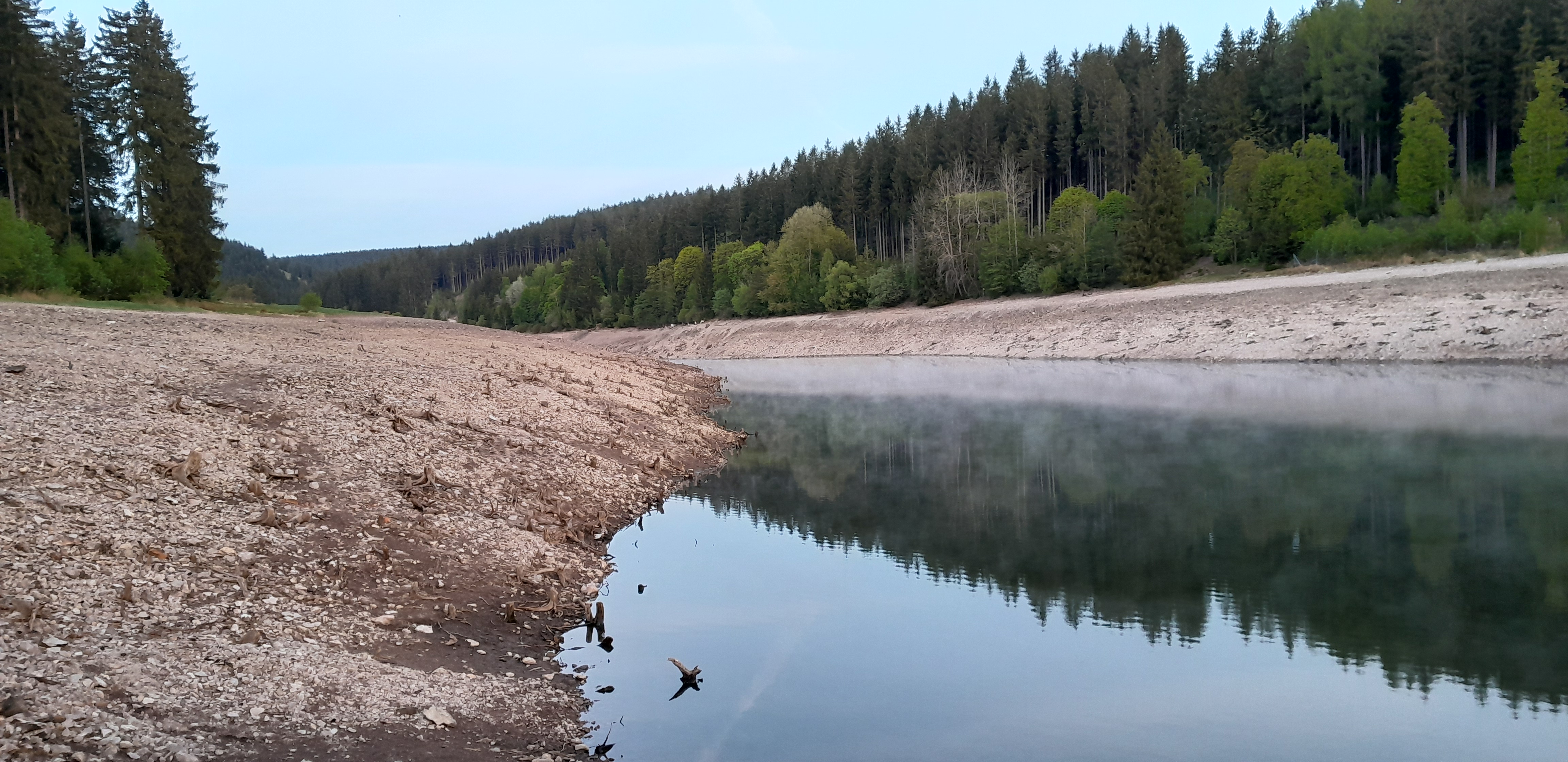 die breiten Uferbereiche aufgrund des geringen Wasserstands und die kleine Wasserfläche sind im Bild