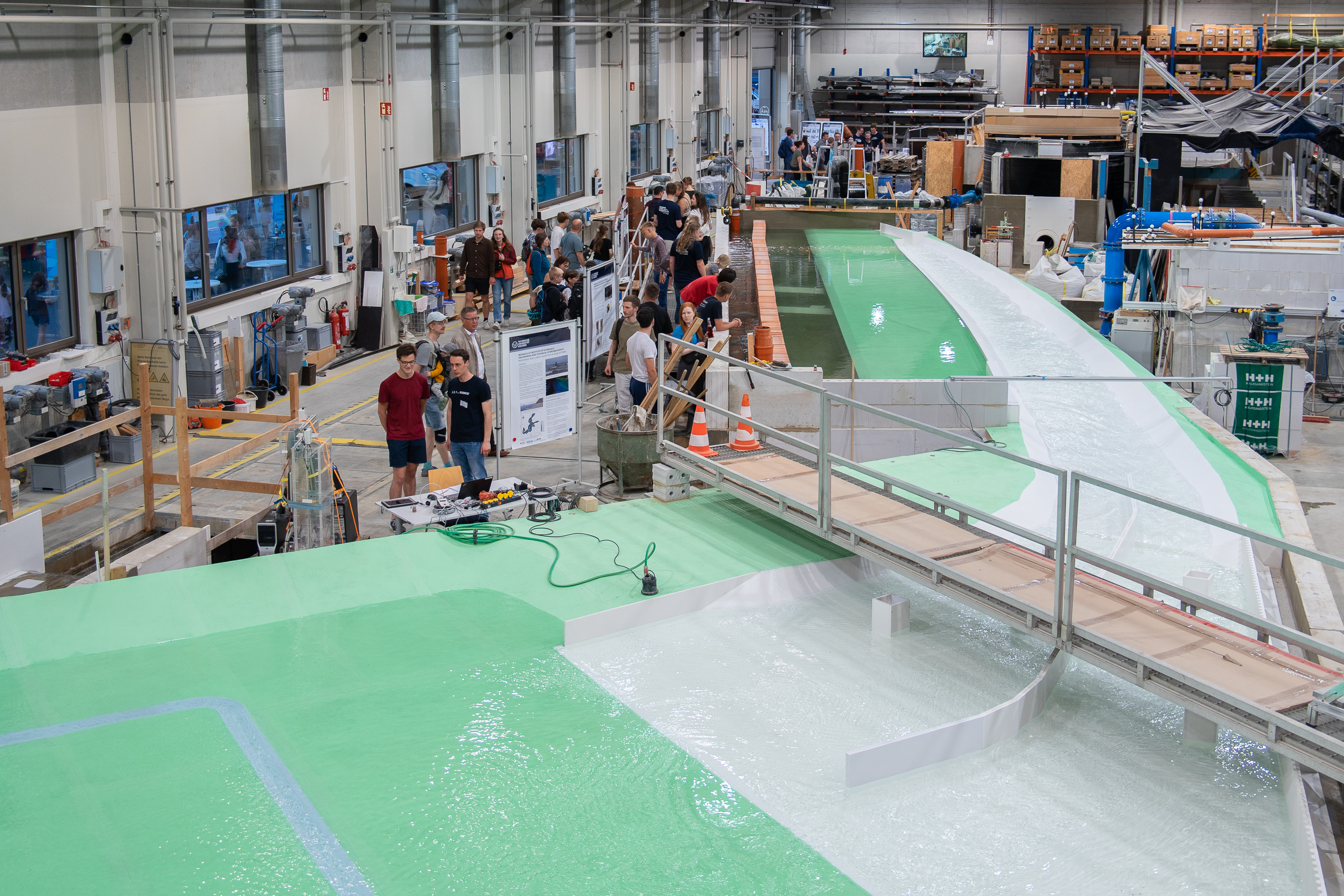 Vogelperspektive auf das Miniaturmodell und auf Besuchende der Langen Nacht der Wissenschaften im Wasserbaulabor an der TU Dresden.
