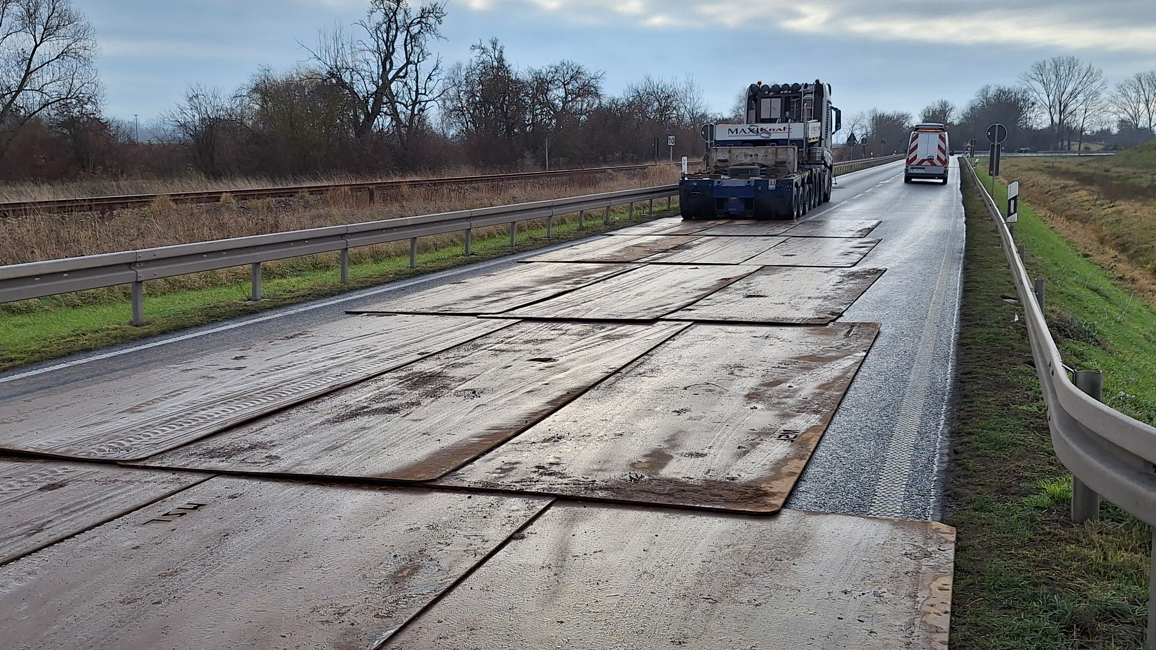 Auf einer Bundesstraße sind Stahlplatten verlegt, um die Last eines Schwertransporters straßenschonend zu verteilen.